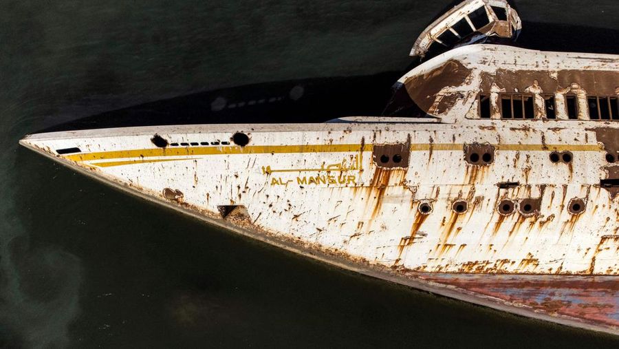 Gambar udara ini menunjukkan lambung terbalik (kiri) Al Mansur (Victorious), kapal pesiar pribadi mantan diktator Irak Saddam Hussein, di jalur air Shatt al-Arab, di kota selatan Irak Basra, pada 28 Februari 2023. (AFP via Getty Images/HUSSEIN FALEH)