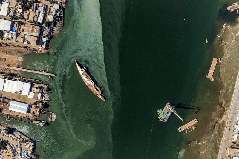 Gambar udara ini menunjukkan lambung terbalik (kiri) Al Mansur (Victorious), kapal pesiar pribadi mantan diktator Irak Saddam Hussein, di jalur air Shatt al-Arab, di kota selatan Irak Basra, pada 28 Februari 2023. (AFP via Getty Images/HUSSEIN FALEH)