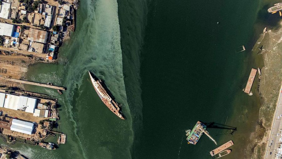 Gambar udara ini menunjukkan lambung terbalik (kiri) Al Mansur (Victorious), kapal pesiar pribadi mantan diktator Irak Saddam Hussein, di jalur air Shatt al-Arab, di kota selatan Irak Basra, pada 28 Februari 2023. (AFP via Getty Images/HUSSEIN FALEH)