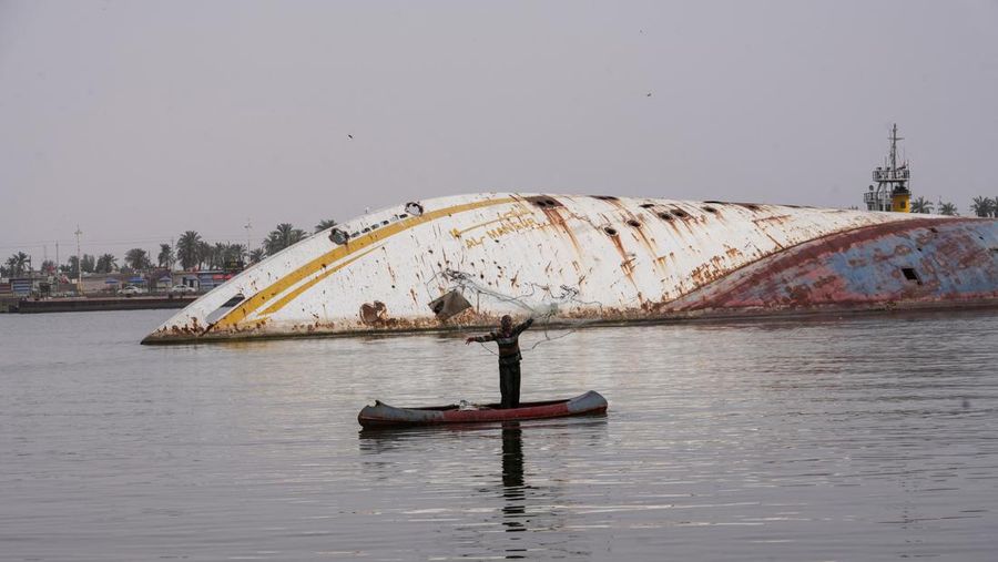 Gambar udara ini menunjukkan lambung terbalik (kiri) Al Mansur (Victorious), kapal pesiar pribadi mantan diktator Irak Saddam Hussein, di jalur air Shatt al-Arab, di kota selatan Irak Basra, pada 28 Februari 2023. (AFP via Getty Images/HUSSEIN FALEH)