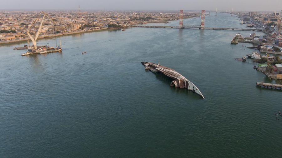 Gambar udara ini menunjukkan lambung terbalik (kiri) Al Mansur (Victorious), kapal pesiar pribadi mantan diktator Irak Saddam Hussein, di jalur air Shatt al-Arab, di kota selatan Irak Basra, pada 28 Februari 2023. (AFP via Getty Images/HUSSEIN FALEH)
