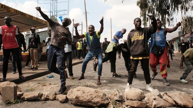 Pendukung pemimpin oposisi Kenya Raila Odinga dari Azimio La Umoja (Deklarasi Persatuan) Aliansi Satu Kenya, melemparkan batu ke petugas polisi anti huru hara saat mereka berpartisipasi dalam protes nasional atas biaya hidup dan pemerintahan Presiden William Ruto di Nairobi, Kenya 20 Maret, 2023. (REUTERS/Thomas Mukoya)