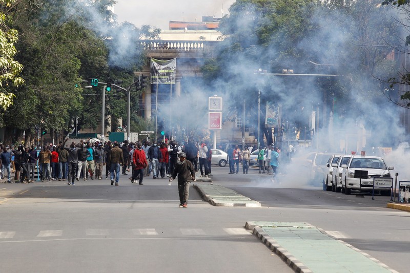 Pendukung pemimpin oposisi Kenya Raila Odinga dari Azimio La Umoja (Deklarasi Persatuan) Aliansi Satu Kenya, melemparkan batu ke petugas polisi anti huru hara saat mereka berpartisipasi dalam protes nasional atas biaya hidup dan pemerintahan Presiden William Ruto di Nairobi, Kenya 20 Maret, 2023. (REUTERS/Thomas Mukoya)