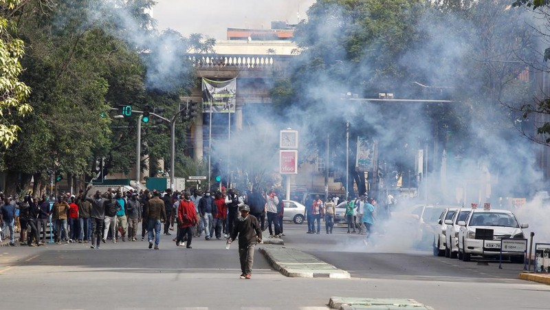 Pendukung pemimpin oposisi Kenya Raila Odinga dari Azimio La Umoja (Deklarasi Persatuan) Aliansi Satu Kenya, melemparkan batu ke petugas polisi anti huru hara saat mereka berpartisipasi dalam protes nasional atas biaya hidup dan pemerintahan Presiden William Ruto di Nairobi, Kenya 20 Maret, 2023. (REUTERS/Thomas Mukoya)