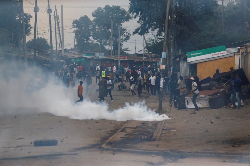 Pendukung pemimpin oposisi Kenya Raila Odinga dari Azimio La Umoja (Deklarasi Persatuan) Aliansi Satu Kenya, melemparkan batu ke petugas polisi anti huru hara saat mereka berpartisipasi dalam protes nasional atas biaya hidup dan pemerintahan Presiden William Ruto di Nairobi, Kenya 20 Maret, 2023. (REUTERS/Thomas Mukoya)