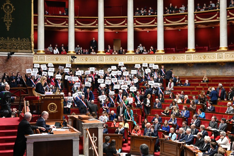Anggota kelompok parlemen Majelis Nasional La France Insoumise (LFI) dan koalisi sayap kiri NUPES (Persatuan Ekologi dan Sosial Rakyat Baru) memegang tanda bertuliskan Anggota kelompok parlemen Majelis Nasional La France Insoumise (LFI) dan koalisi sayap kiri NUPES (Persatuan Ekologi dan Sosial Rakyat Baru) memegang tanda bertuliskan