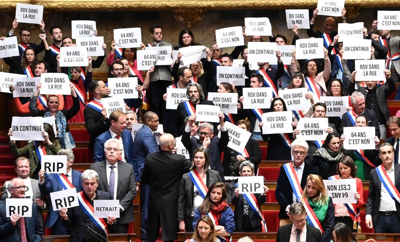 Anggota kelompok parlemen Majelis Nasional La France Insoumise (LFI) dan koalisi sayap kiri NUPES (Persatuan Ekologi dan Sosial Rakyat Baru) memegang tanda bertuliskan 