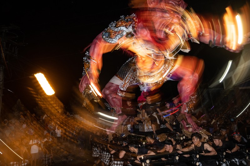 Pemuda Bali membawa ogoh-ogoh, boneka raksasa yang tampak mengancam saat pawai ogoh-ogoh pada malam Nyepi, Hari Raya Nyepi umat Hindu Bali yang menandai datangnya tahun baru Saka bulan pada 20 Maret 2023 di Tegalalang Desa, Gianyar, Bali, Indonesia. Pemuda Bali membawa ogoh-ogoh, boneka raksasa yang tampak mengancam saat pawai ogoh-ogoh pada malam Nyepi, Hari Raya Nyepi umat Hindu Bali yang menandai datangnya tahun baru Saka bulan pada 20 Maret 2023 di Tegalalang Desa, Gianyar, Bali, Indonesia. Umat Hindu di Bali melakukan serangkaian ritual pada awal Maret untuk merayakan tahun baru Imlek yang berpuncak pada perayaan Nyepi. Ogoh-ogoh menjadi salah satu pawai di awal tahun 1980-an. Sebelumnya, para peserta berkeliaran di jalan-jalan membawa obor bambu dan membuat suara keras dengan instrumen perkusi untuk menakut-nakuti setan. Di Bali masa kini, mayoritas ogoh-ogoh dibangun oleh anggota seka teruna teruni, sayap pemuda banjar. Nyepi berasal dari kata sepi atau sipeng yang artinya sepi, sepi, hening, nol, kosong, tidak ramai, tidak berisik, dan tidak ada aktivitas. Sejak tahun 1983, Nyepi menjadi hari libur nasional. Perayaan hari raya Nyepi bagi umat Hindu Bali di Indonesia merupakan kesempatan untuk refleksi diri yang disebut dengan mulat sarira. Semua penghuni dan pengunjung diwajibkan untuk mematuhi aturan yang disebut Catur Brata Penyepian, yang terdiri dari: tidak menyalakan api atau nyala api, tidak melakukan kegiatan yang menyenangkan, tidak bekerja atau bekerja, dan tidak melakukan perjalanan. (Agung Parameswara/Getty Images)