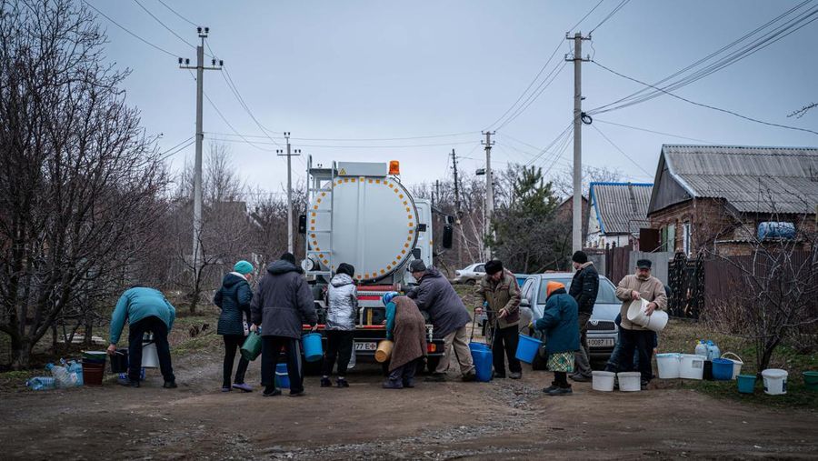 Penduduk Ukraina mengumpulkan air dari truk tangki yang disediakan oleh pemadam kebakaran di Kostyantynivka, Ukraina. (Anadolu Agency via Getty Images)