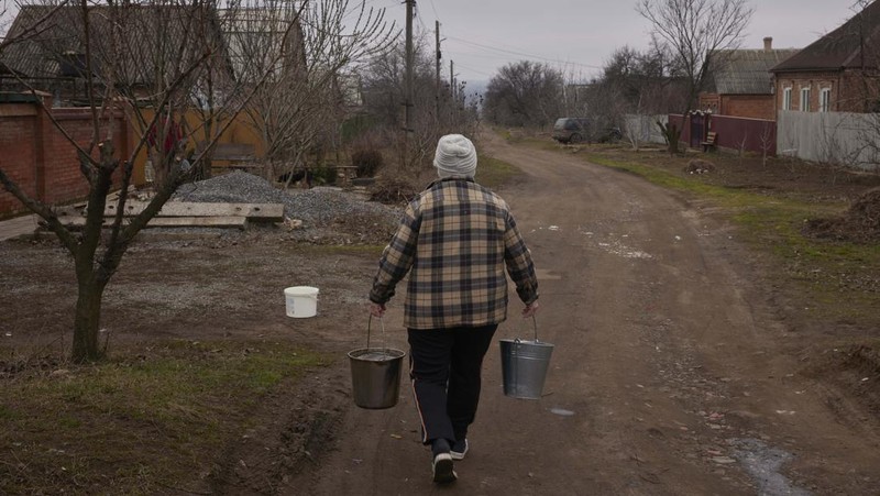 Penduduk Ukraina mengumpulkan air dari truk tangki yang disediakan oleh pemadam kebakaran di Kostyantynivka, Ukraina. (Anadolu Agency via Getty Images)