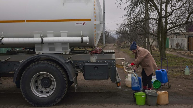 Penduduk Ukraina mengumpulkan air dari truk tangki yang disediakan oleh pemadam kebakaran di Kostyantynivka, Ukraina. (Anadolu Agency via Getty Images)