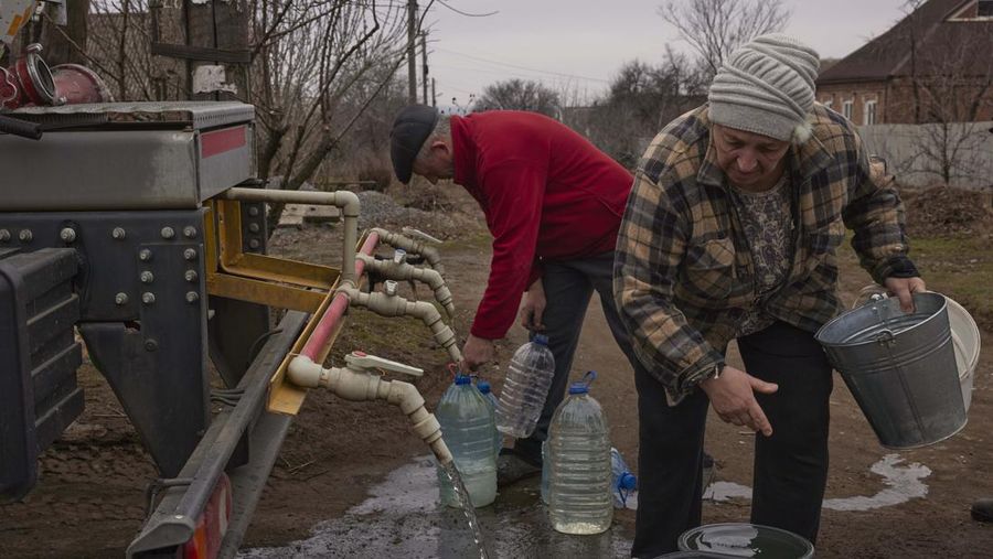 Penduduk Ukraina mengumpulkan air dari truk tangki yang disediakan oleh pemadam kebakaran di Kostyantynivka, Ukraina. (Anadolu Agency via Getty Images)