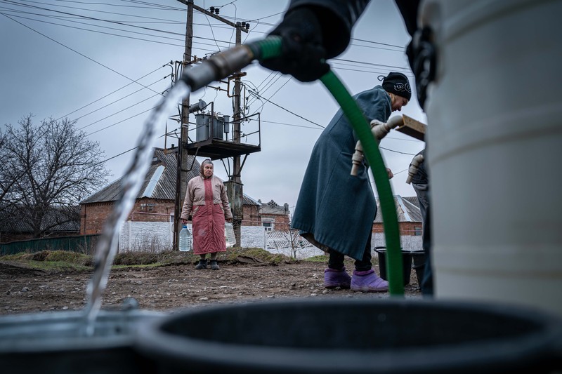 Penduduk Ukraina mengumpulkan air dari truk tangki yang disediakan oleh pemadam kebakaran di Kostyantynivka, Ukraina. (Anadolu Agency via Getty Images)