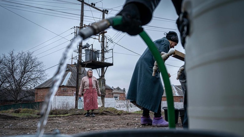 Penduduk Ukraina mengumpulkan air dari truk tangki yang disediakan oleh pemadam kebakaran di Kostyantynivka, Ukraina. (Anadolu Agency via Getty Images)