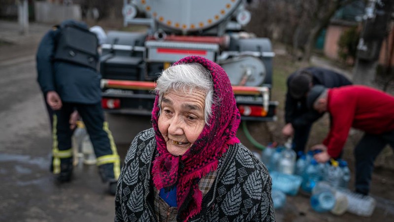 Penduduk Ukraina mengumpulkan air dari truk tangki yang disediakan oleh pemadam kebakaran di Kostyantynivka, Ukraina. (Anadolu Agency via Getty Images)