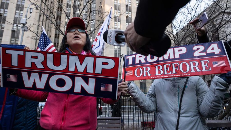 Pendukung mantan Presiden Donald Trump melakukan protes di dekat kantor Kejaksaan Distrik Manhattan Alvin Brag dan Pengadilan Kriminal New York County pada 20 Maret 2023 di New York City. Trump memposting di media sosial bahwa dia berharap akan ditangkap sehubungan dengan penyelidikan di New York atas skema uang tutup mulut yang melibatkan aktris film dewasa Stormy Daniels dan meminta para pendukungnya untuk memprotes tindakan tersebut. (Alexi J. Rosenfeld/Getty Images)