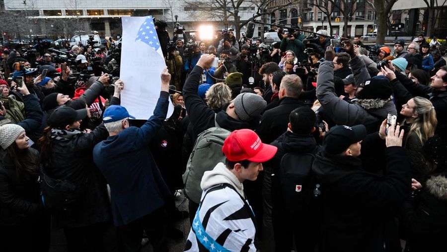 Pendukung mantan Presiden Donald Trump melakukan protes di dekat kantor Kejaksaan Distrik Manhattan Alvin Brag dan Pengadilan Kriminal New York County pada 20 Maret 2023 di New York City. Trump memposting di media sosial bahwa dia berharap akan ditangkap sehubungan dengan penyelidikan di New York atas skema uang tutup mulut yang melibatkan aktris film dewasa Stormy Daniels dan meminta para pendukungnya untuk memprotes tindakan tersebut. (Alexi J. Rosenfeld/Getty Images)