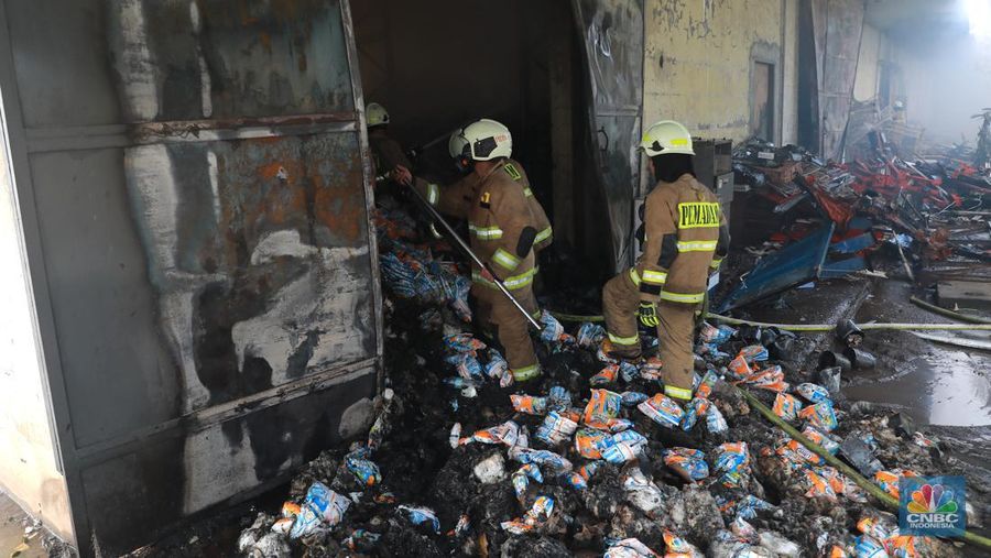 Petugas pemadam kebakaran memadamkan api saat kebakaran gudang sembako Indogrosir Cipinang di Kelurahan Pisangan Timur, Kecamatan Pulogadung, Jakarta Timur, Selasa (21/3/2023). (CNBC Indonesia/Muhammad Sabki)