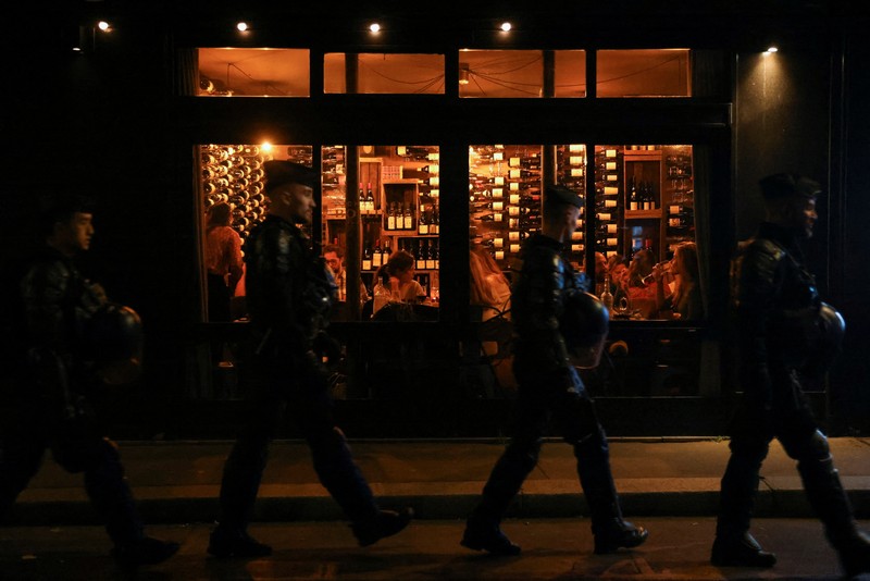 Orang-orang menonton wawancara TV Presiden Prancis Emmanuel Macron dari sebuah restoran bar di Toulouse, Prancis barat daya pada 22 Maret 2023. Orang-orang menonton wawancara TV Presiden Prancis Emmanuel Macron dari sebuah restoran bar di Toulouse, Prancis barat daya pada 22 Maret 2023. - Presiden Prancis akan membuat komentar publik pertamanya pada 22 Maret 2023 tentang krisis yang dipicu oleh pemerintahnya yang memaksakan perombakan pensiun , yang telah memicu protes keras dan pertanyaan tentang kemampuannya untuk membawa perubahan lebih lanjut. (CHARLY TRIBALLEAU/AFP via Getty Images)