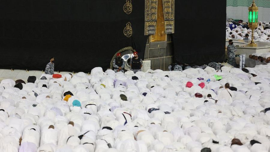 Pasukan keamanan Saudi berjaga-jaga saat jamaah berdoa di depan Ka'bah, tempat suci Islam yang paling suci, di Masjidil Haram di kota suci Mekkah pada 21 Maret 2023, saat Arab Saudi, rumah dari tempat suci paling suci dalam Islam, mengumumkan bahwa bulan puasa Ramadan akan dimulai dari 23 Maret. (Abdel Ghani BASHIR / AFP) (Photo by ABDEL GHANI BASHIR/AFP via Getty Images)