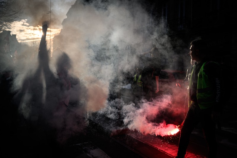 Seorang petugas polisi Prancis dengan pakaian anti huru hara berdiri di samping api selama demonstrasi di Bordeaux, Prancis (AFP via Getty Images/THIBAUD MORITZ) Seorang petugas polisi Prancis dengan pakaian anti huru hara berdiri di samping api selama demonstrasi di Bordeaux, Prancis (AFP via Getty Images/THIBAUD MORITZ)