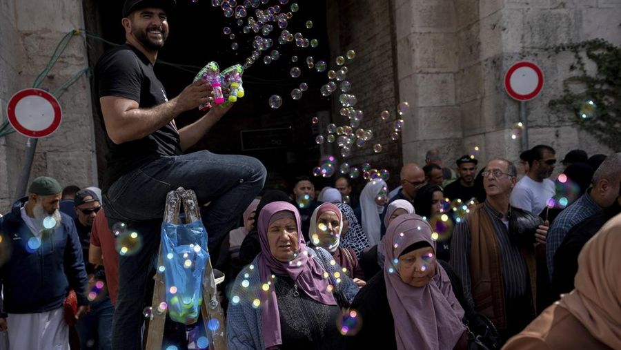 Pasukan Israel mengambil langkah-langkah keamanan saat warga Palestina melewati pos pemeriksaan yang memisahkan Bethlehem dan Yerusalem, untuk menghadiri sholat Jumat pertama bulan suci Ramadhan di Masjid Al-Aqsa pada dini hari di Bethlehem. (Anadolu Agency via Getty Images)