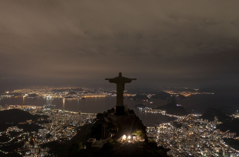 Patung Kristus Penebus terlihat setelah gelap gulita untuk Earth Hour pada (26/3/2023) di Rio de Janeiro, Brasil. (AFP via Getty Images/MAURO PIMENTEL)