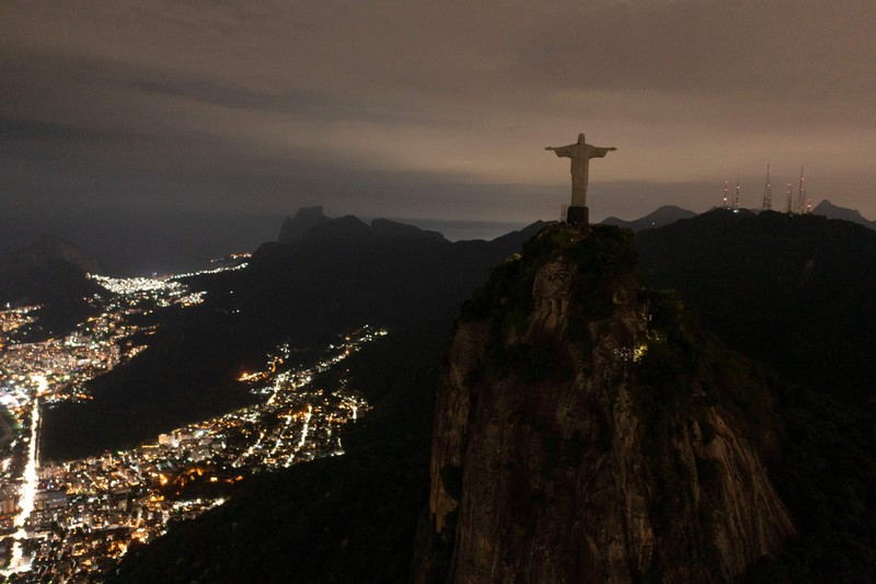 Patung Kristus Penebus terlihat setelah gelap gulita untuk Earth Hour pada (26/3/2023) di Rio de Janeiro, Brasil. (AFP via Getty Images/MAURO PIMENTEL) Patung Kristus Penebus terlihat setelah gelap gulita untuk Earth Hour pada (26/3/2023) di Rio de Janeiro, Brasil. (AFP via Getty Images/MAURO PIMENTEL)