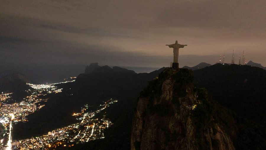 Patung Kristus Penebus terlihat setelah gelap gulita untuk Earth Hour pada (26/3/2023) di Rio de Janeiro, Brasil. (AFP via Getty Images/MAURO PIMENTEL)