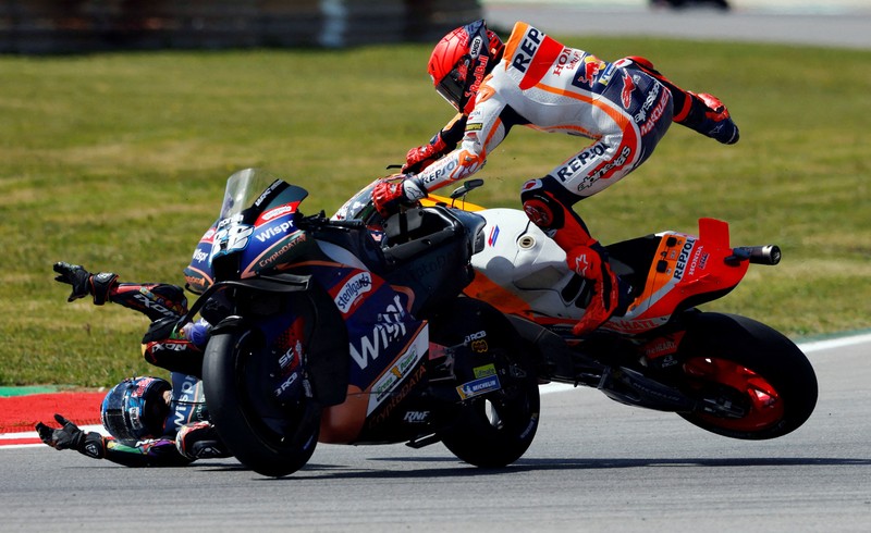 MOTOR-MOTOGP-PORTUGAL/ MotoGP - Portuguese Grand Prix - Algarve International Circuit, Portimao, Portugal - March 26, 2023 Repsol Honda Team's Marc Marquez and CryptoDATA RNF MotoGP Team's Miguel Oliveira after crashing during the race REUTERS/Marcelo Del Pozo TPX IMAGES OF THE DAY
