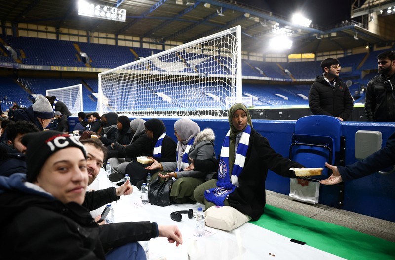 RELIGION-RAMADAN/BRITAIN People have their iftar (breaking fast) meal pitch side at Stamford Bridge stadium, the ground of Chelsea Football Club, during Ramadan in London, Britain, March 26, 2023. REUTERS/Henry Nicholls