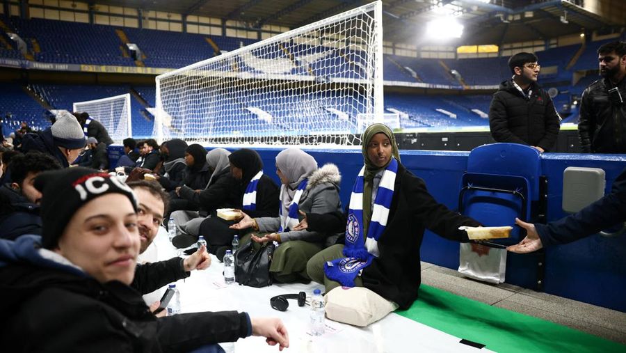 People have their iftar (breaking fast) meal pitch side at Stamford Bridge stadium, the ground of Chelsea Football Club, during Ramadan in London, Britain, March 26, 2023. REUTERS/Henry Nicholls