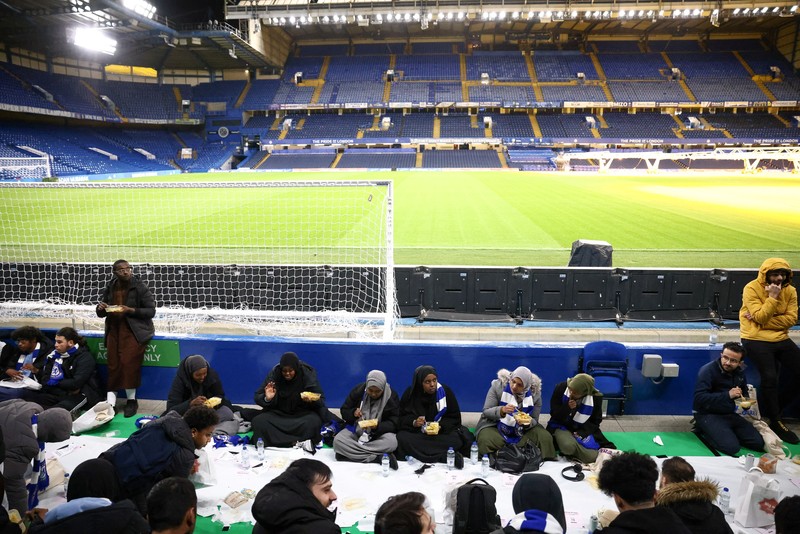 RELIGION-RAMADAN/BRITAIN People have their iftar (breaking fast) meal pitch side at Stamford Bridge stadium, the ground of Chelsea Football Club, during Ramadan in London, Britain, March 26, 2023. REUTERS/Henry Nicholls