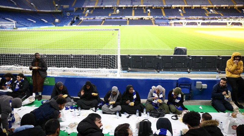 People have their iftar (breaking fast) meal pitch side at Stamford Bridge stadium, the ground of Chelsea Football Club, during Ramadan in London, Britain, March 26, 2023. REUTERS/Henry Nicholls
