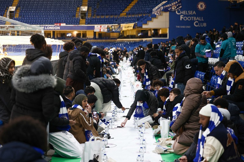People have their iftar (breaking fast) meal pitch side at Stamford Bridge stadium, the ground of Chelsea Football Club, during Ramadan in London, Britain, March 26, 2023. REUTERS/Henry Nicholls