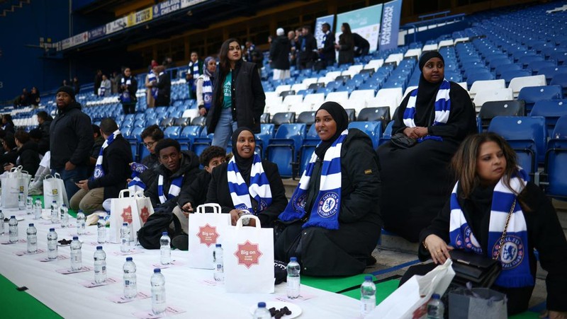 People have their iftar (breaking fast) meal pitch side at Stamford Bridge stadium, the ground of Chelsea Football Club, during Ramadan in London, Britain, March 26, 2023. REUTERS/Henry Nicholls