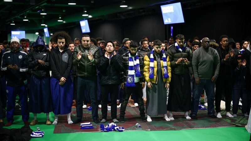 People have their iftar (breaking fast) meal pitch side at Stamford Bridge stadium, the ground of Chelsea Football Club, during Ramadan in London, Britain, March 26, 2023. REUTERS/Henry Nicholls