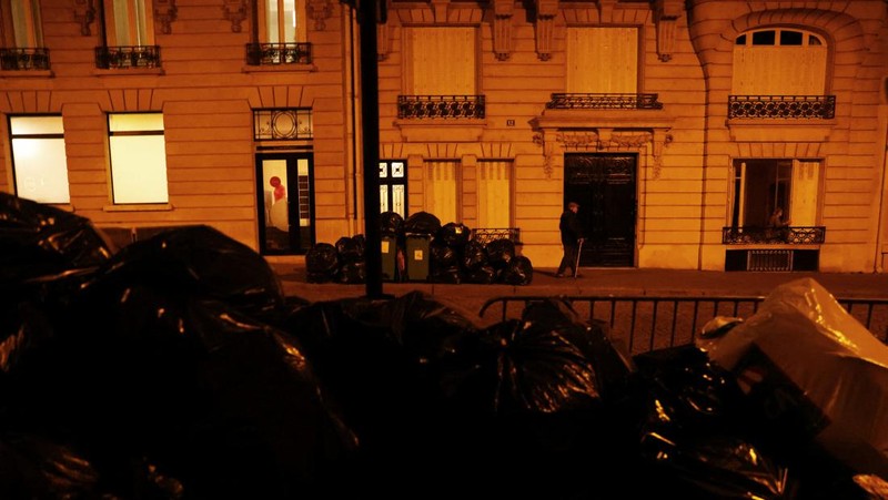 Newlyweds Fabiana, 44, and Rob Burns, 53, from the U.S., pose for a photographer in front of overflowing garbage bins in a street near the Eiffel Tower as garbage has not been collected due to a strike of garbage collectors against the French government pension reform, in Paris, France, March 27, 2023. REUTERS/Nacho Doce     TPX IMAGES OF THE DAY
