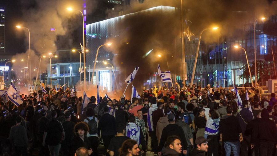 Israeli protesters react as a water cannon is used to disperse the people attending a demonstration against Israeli Prime Minister Benjamin Netanyahu and his nationalist coalition government's plan for judicial overhaul, in Tel Aviv, Israel, March 27, 2023. REUTERS/Itai Ron  NO RESALES. NO ARCHIVES