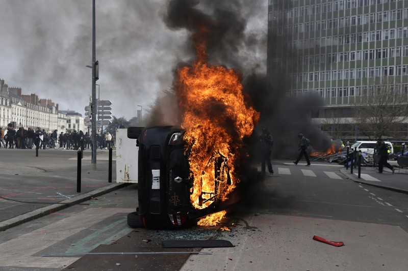 French firefighters try to extinguish a burning BNP Paribas bank office during clashes at a demonstration as part of the tenth day of nationwide strikes and protests against French government's pension reform in Nantes, France, March 28, 2023.   REUTERS/Stephane Mahe