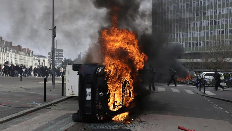French firefighters try to extinguish a burning BNP Paribas bank office during clashes at a demonstration as part of the tenth day of nationwide strikes and protests against French government's pension reform in Nantes, France, March 28, 2023.   REUTERS/Stephane Mahe