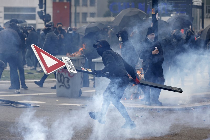 French firefighters try to extinguish a burning BNP Paribas bank office during clashes at a demonstration as part of the tenth day of nationwide strikes and protests against French government's pension reform in Nantes, France, March 28, 2023.   REUTERS/Stephane Mahe