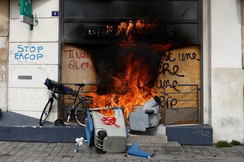 French firefighters try to extinguish a burning BNP Paribas bank office during clashes at a demonstration as part of the tenth day of nationwide strikes and protests against French government's pension reform in Nantes, France, March 28, 2023.   REUTERS/Stephane Mahe