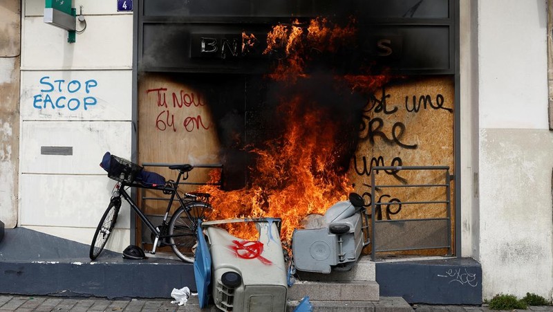 French firefighters try to extinguish a burning BNP Paribas bank office during clashes at a demonstration as part of the tenth day of nationwide strikes and protests against French government's pension reform in Nantes, France, March 28, 2023.   REUTERS/Stephane Mahe