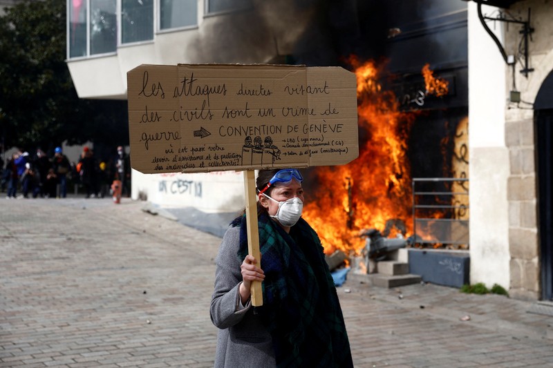 French firefighters try to extinguish a burning BNP Paribas bank office during clashes at a demonstration as part of the tenth day of nationwide strikes and protests against French government's pension reform in Nantes, France, March 28, 2023.   REUTERS/Stephane Mahe