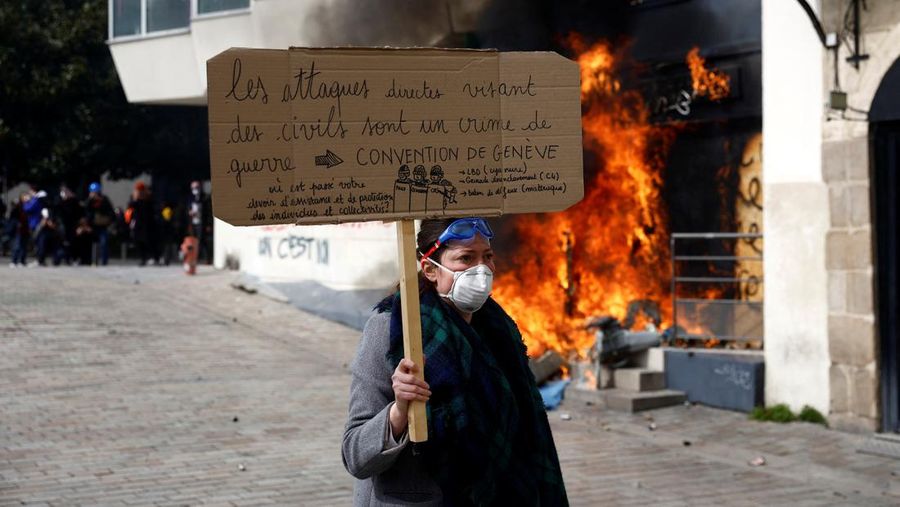 French firefighters try to extinguish a burning BNP Paribas bank office during clashes at a demonstration as part of the tenth day of nationwide strikes and protests against French government's pension reform in Nantes, France, March 28, 2023.   REUTERS/Stephane Mahe