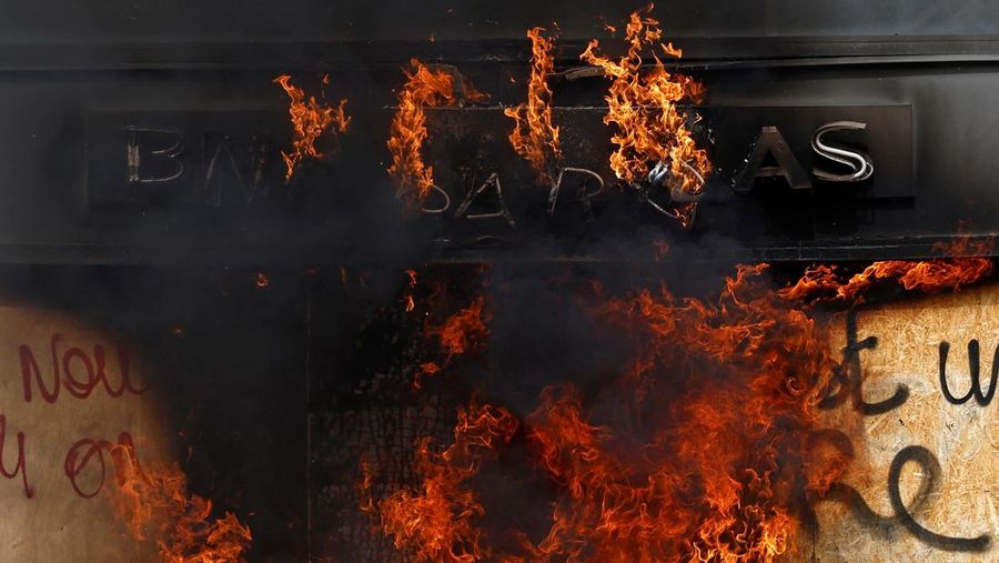 French firefighters try to extinguish a burning BNP Paribas bank office during clashes at a demonstration as part of the tenth day of nationwide strikes and protests against French government's pension reform in Nantes, France, March 28, 2023.   REUTERS/Stephane Mahe
