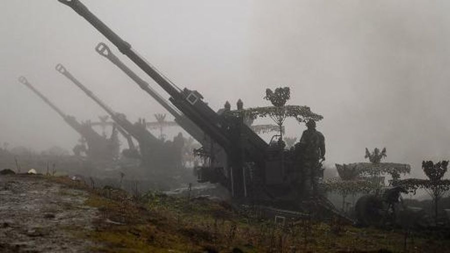 Indian Army soldiers stand next to Bofors guns positioned at Penga Teng Tso ahead of Tawang, near the Line of Actual Control (LAC), neighbouring China, in India's Arunachal Pradesh state on October 20, 2021. (Photo by Money SHARMA / AFP)