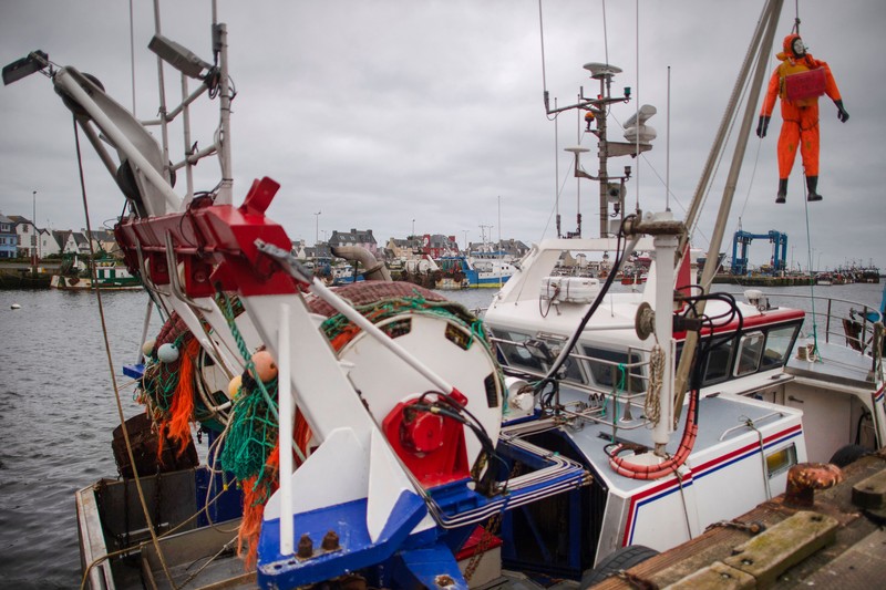 Sebuah foto memperlihatkan patung seorang nelayan, menunjukkan di atas kapal penangkap ikan sebuah kartu bertuliskan Sebuah foto memperlihatkan patung seorang nelayan, menunjukkan di atas kapal penangkap ikan sebuah kartu bertuliskan