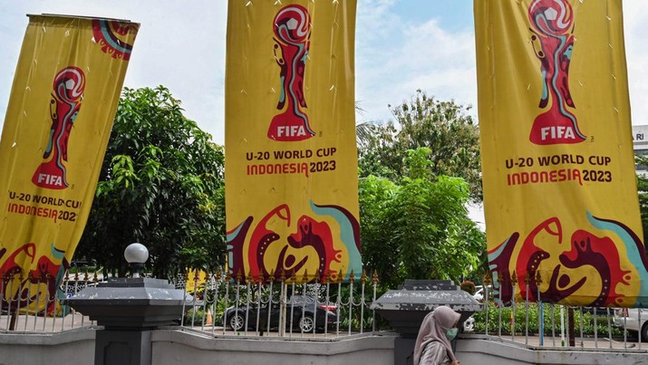 Seorang wanita berjalan melewati spanduk untuk turnamen sepak bola Piala Dunia FIFA U-20 Indonesia 2023 di Jakarta pada 30 Maret 2023. Seorang wanita berjalan melewati spanduk untuk turnamen sepak bola Piala Dunia FIFA U-20 Indonesia 2023 di Jakarta pada 30 Maret 2023. - FIFA mengumumkan pada 29 Maret telah menghapus Indonesia sebagai tuan rumah Piala Dunia U-20 tahun ini di tengah kekacauan politik atas Israel partisipasi. (ADEK BERRY/AFP via Getty Images)